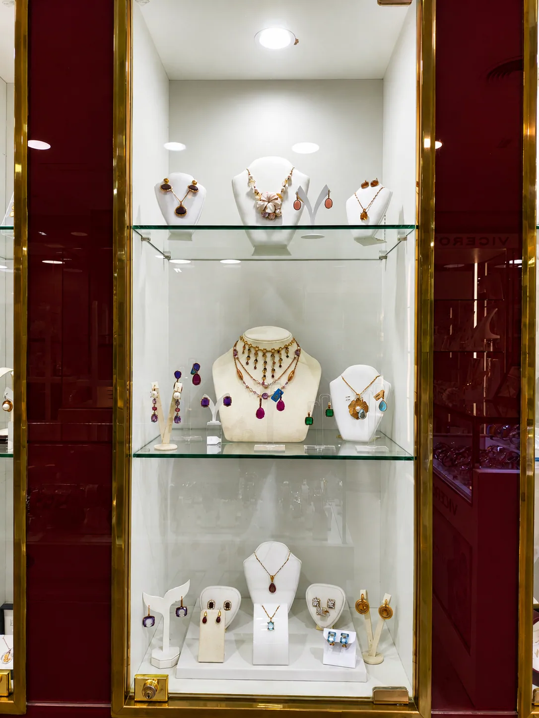 Vitrina de joyería con piedras de colores sobre terciopelo marfil